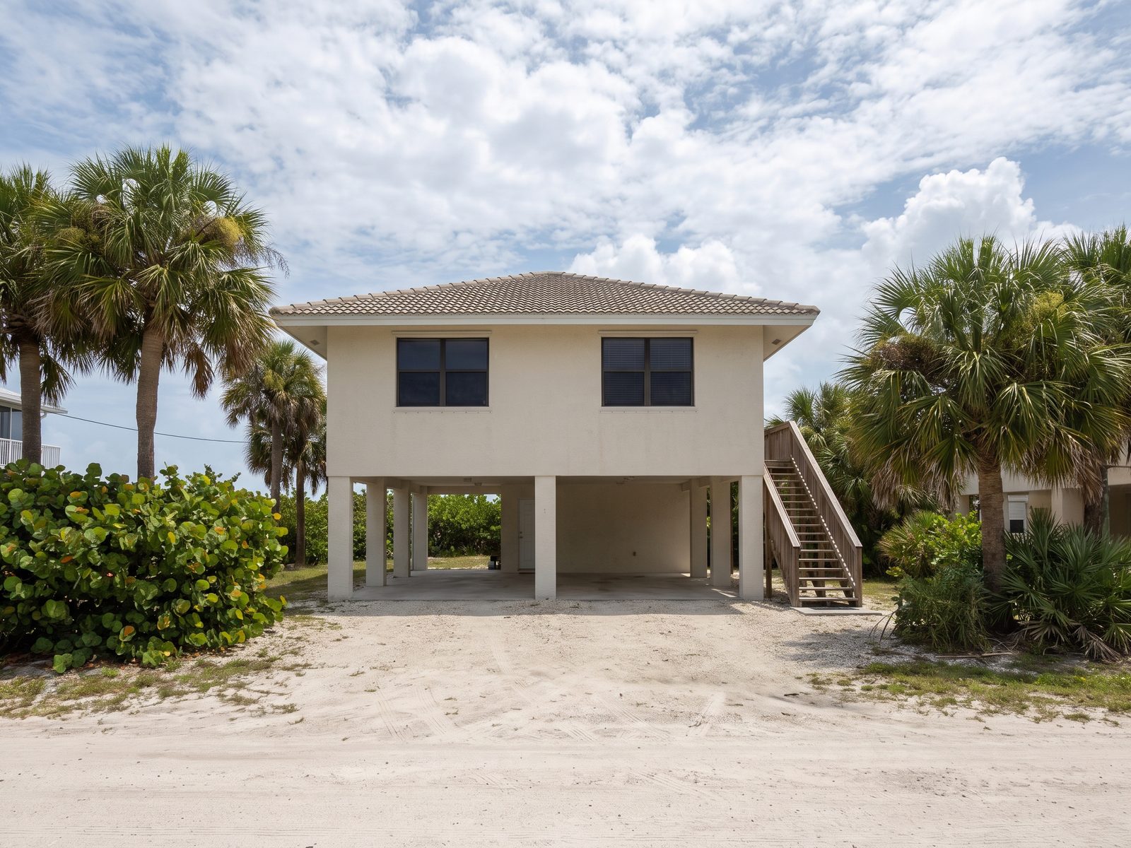 Elevated Coastal Home Florida | Restoration Doctor Elevated coastal South Florida home on concrete piers with open parking underneath.
