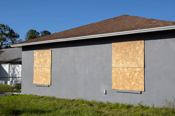 Boarded up windows with plywood storm shutters for hurricane protection of residential house. Protective measures before natural disaster in Florida.